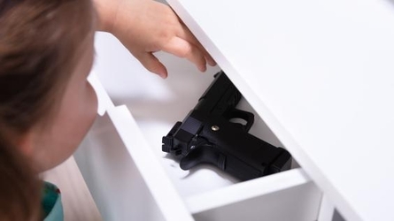 child reaching for gun